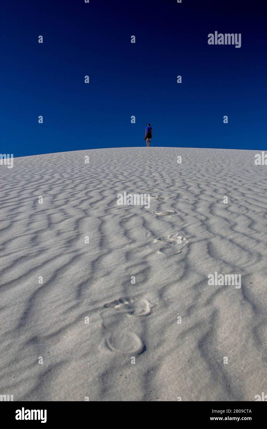 Persona caminando sobre dunas de arena blanca, Monumento Nacional White Sands, Nuevo México Foto de stock