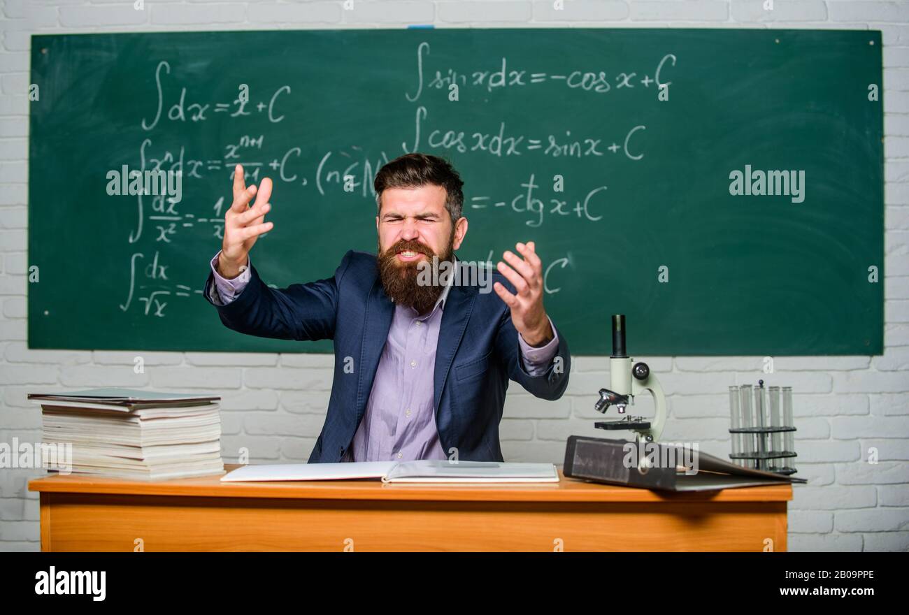 Salga de clase. El director de la escuela amenaza con castigo. Maestro estricto grave barbudo hombre fondo pizarra. El maestro parece amenazador. Reglas de conducta escolar. Maestro exigente. Foto de stock