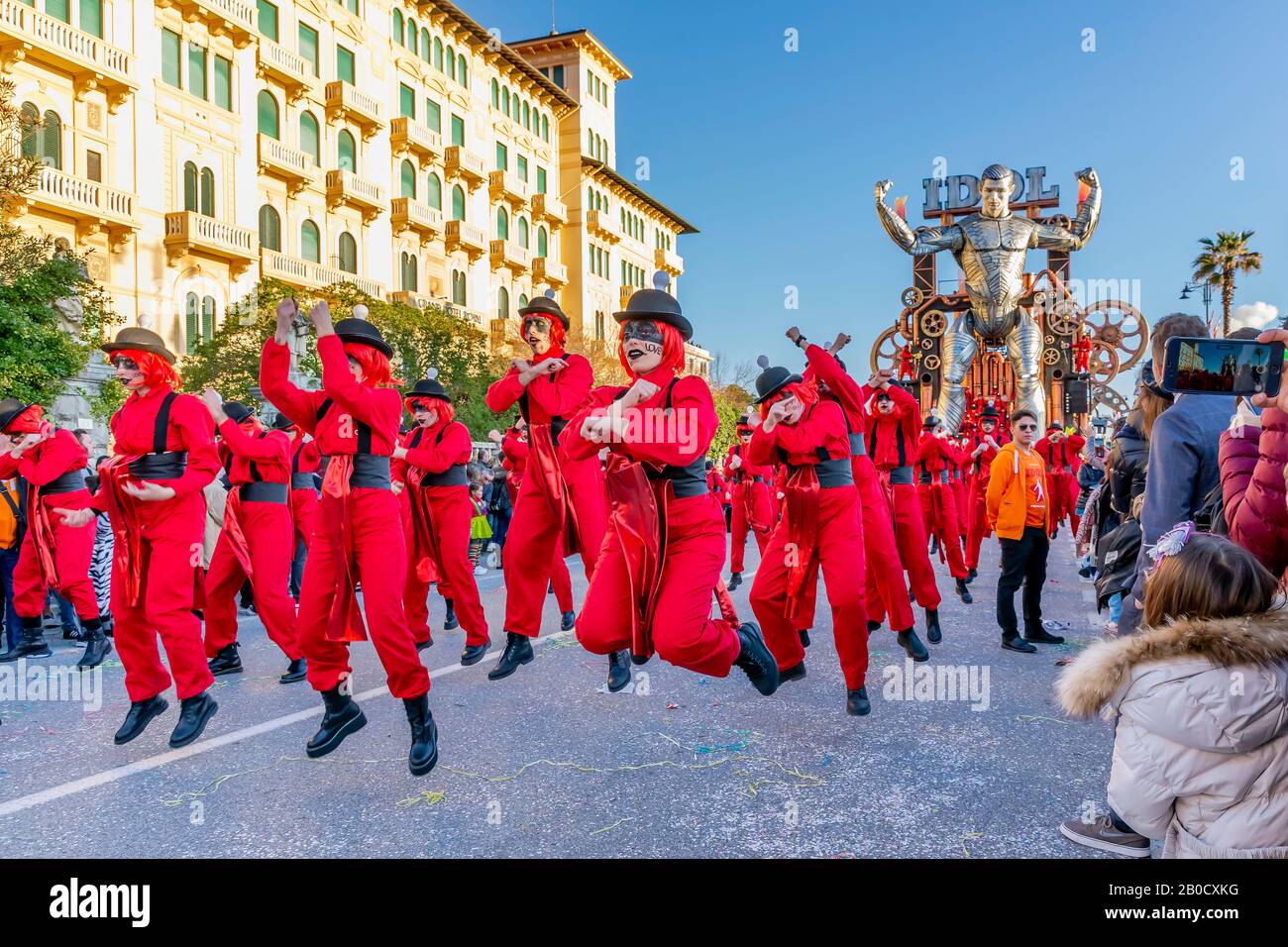 Figuras enmascaradas bailando en la calle con el flotador alegórico "Idol"  en el fondo, Carnaval de Viareggio, Italia Fotografía de stock - Alamy