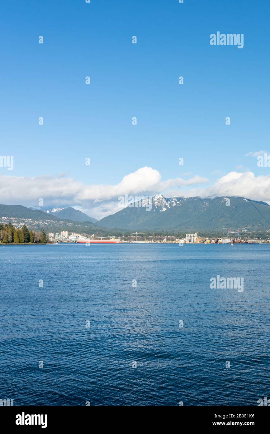 Vancouver, British Columbia, Canadá - Diciembre de 2019 - Vista a la montaña con nubes en un hermoso día de cielo azul en el puerto de la costa oeste. Foto de stock