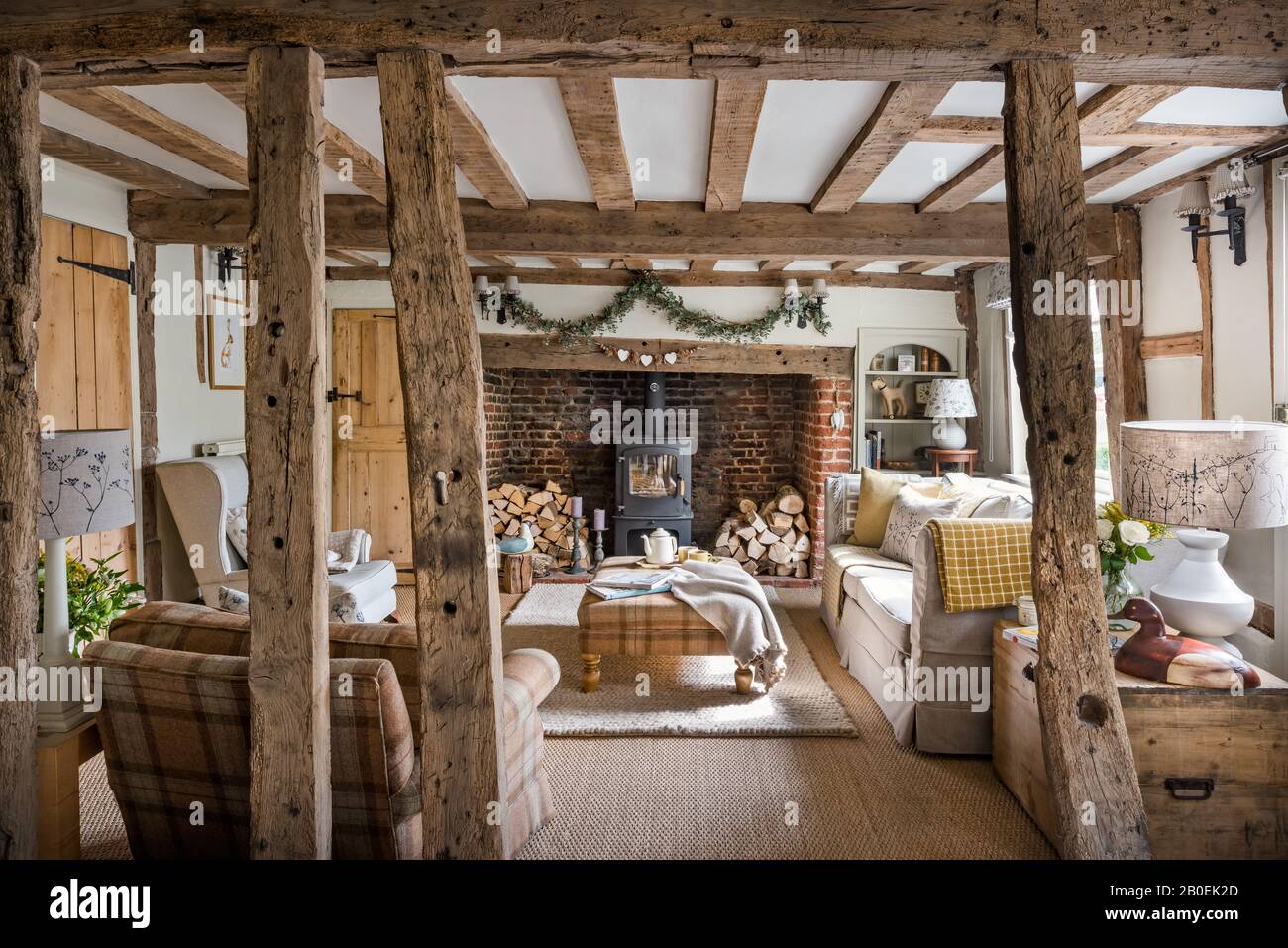 Sala de estar con marcos de madera de grado II pintada en Farrow & Ball's Off White con alfombra Jacaranda Pebbles tejida a mano. Foto de stock