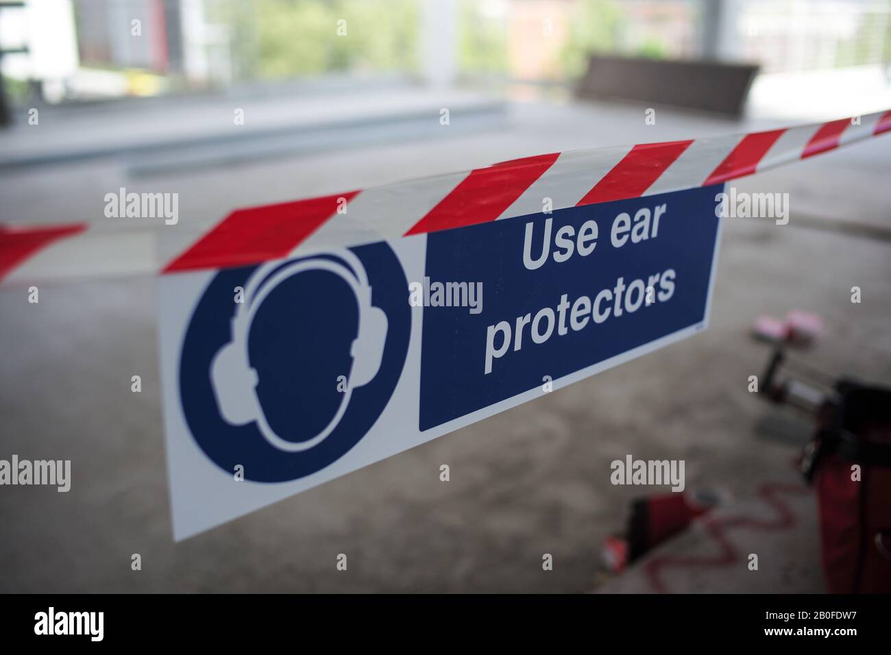Señales de advertencia en un edificio para usar un dispositivo de protección auditiva para los trabajadores de la construcción en una zona ruidosa. Foto de stock
