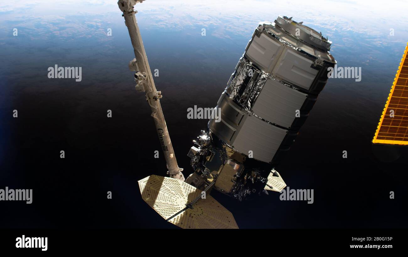 La nave espacial Northrop Grumman Cygnus con los distintos paneles solares en forma de cimbal es grapada por el CanadaArm2 en la Estación Espacial Internacional el 18 de febrero de 2020 en Órbita terrestre. La nave de carga no tripulada está llevando más de 7,500 libras de suministros para la tripulación del laboratorio de orbitación. Foto de stock