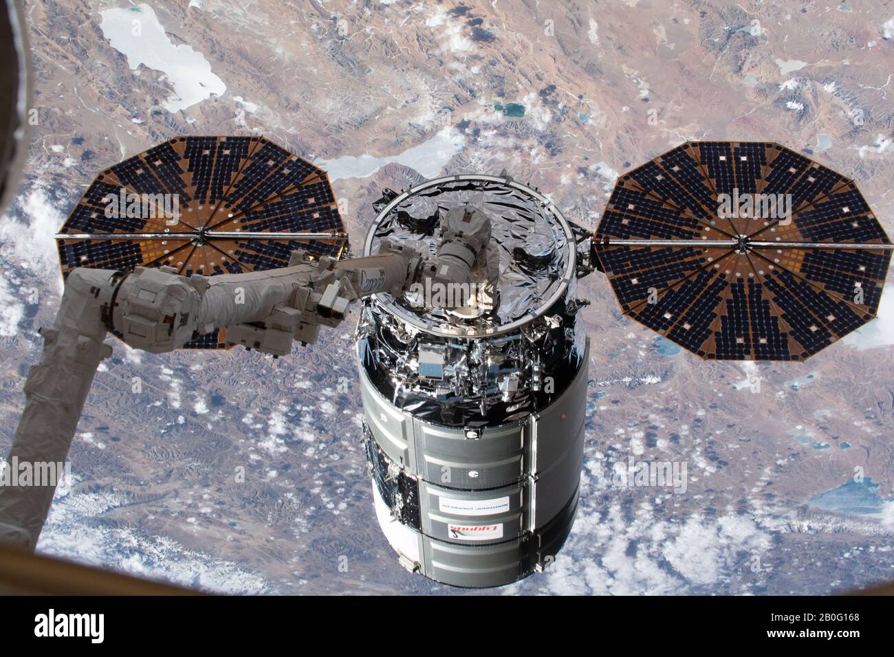 La nave espacial Northrop Grumman Cygnus con los distintos paneles solares en forma de platillo es grapada por el CanadaArm2 para atracar en la Estación Espacial Internacional el 18 de febrero de 2020 en Órbita terrestre. La nave de carga no tripulada está llevando más de 7,500 libras de suministros para la tripulación del laboratorio de orbitación. Foto de stock