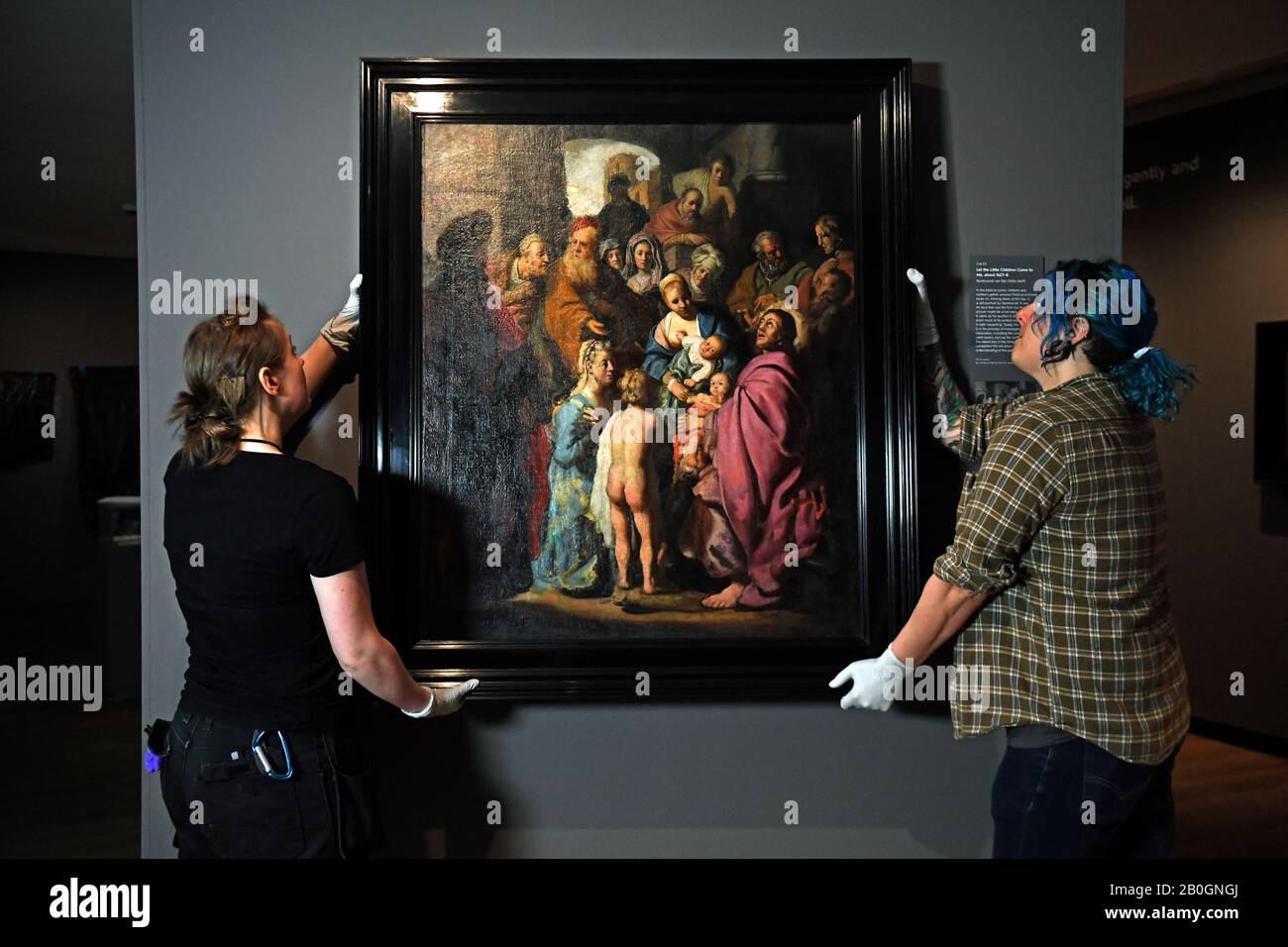 Los manipuladores de arte se ajustan a 'Let the Little Children Come to Me', un recién descubierto Rembrandt, en el Ashmolean Museum en Oxford. Foto de stock