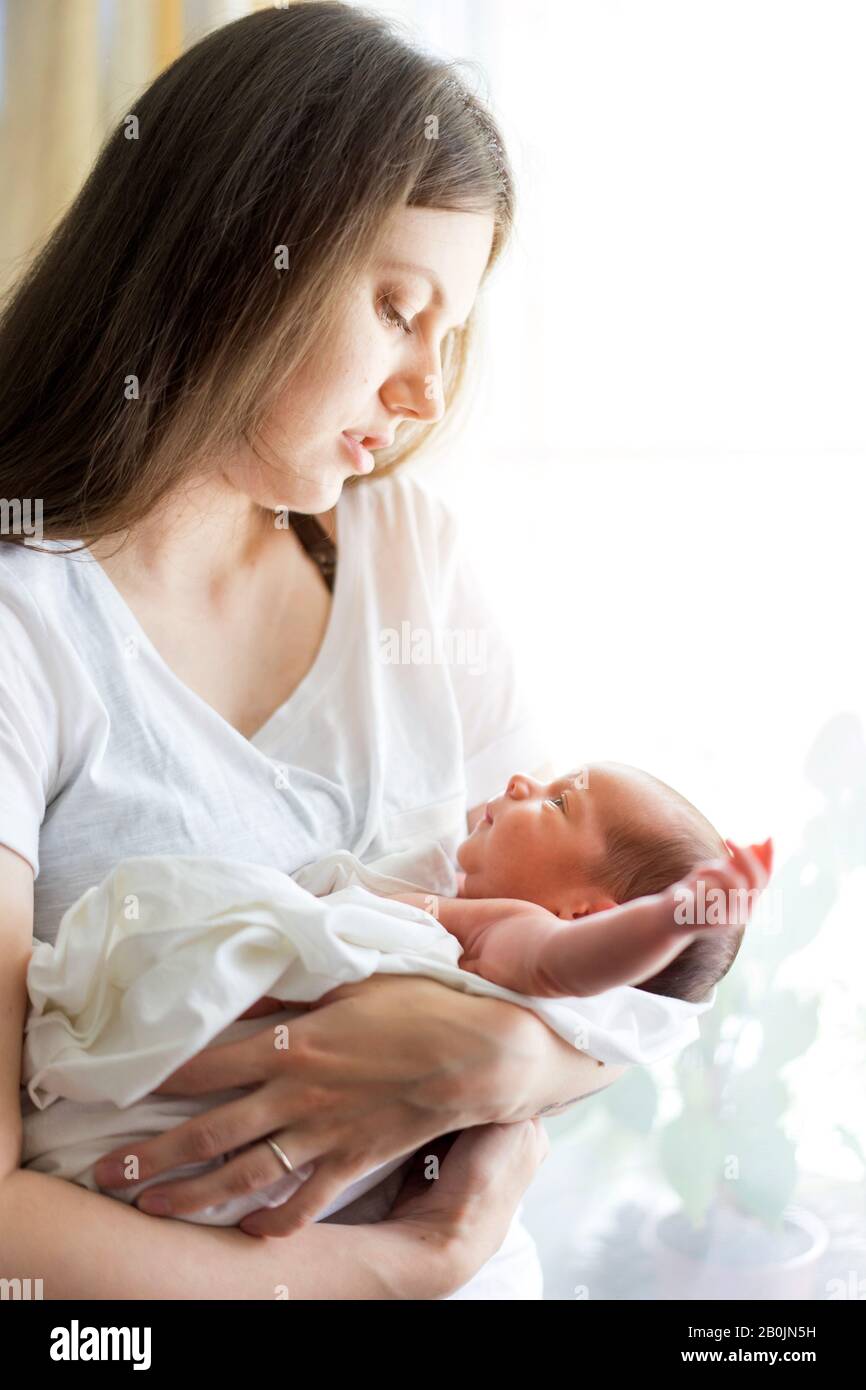Una madre con un bebé recién nacido en sus brazos es la lactancia materna él Foto de stock
