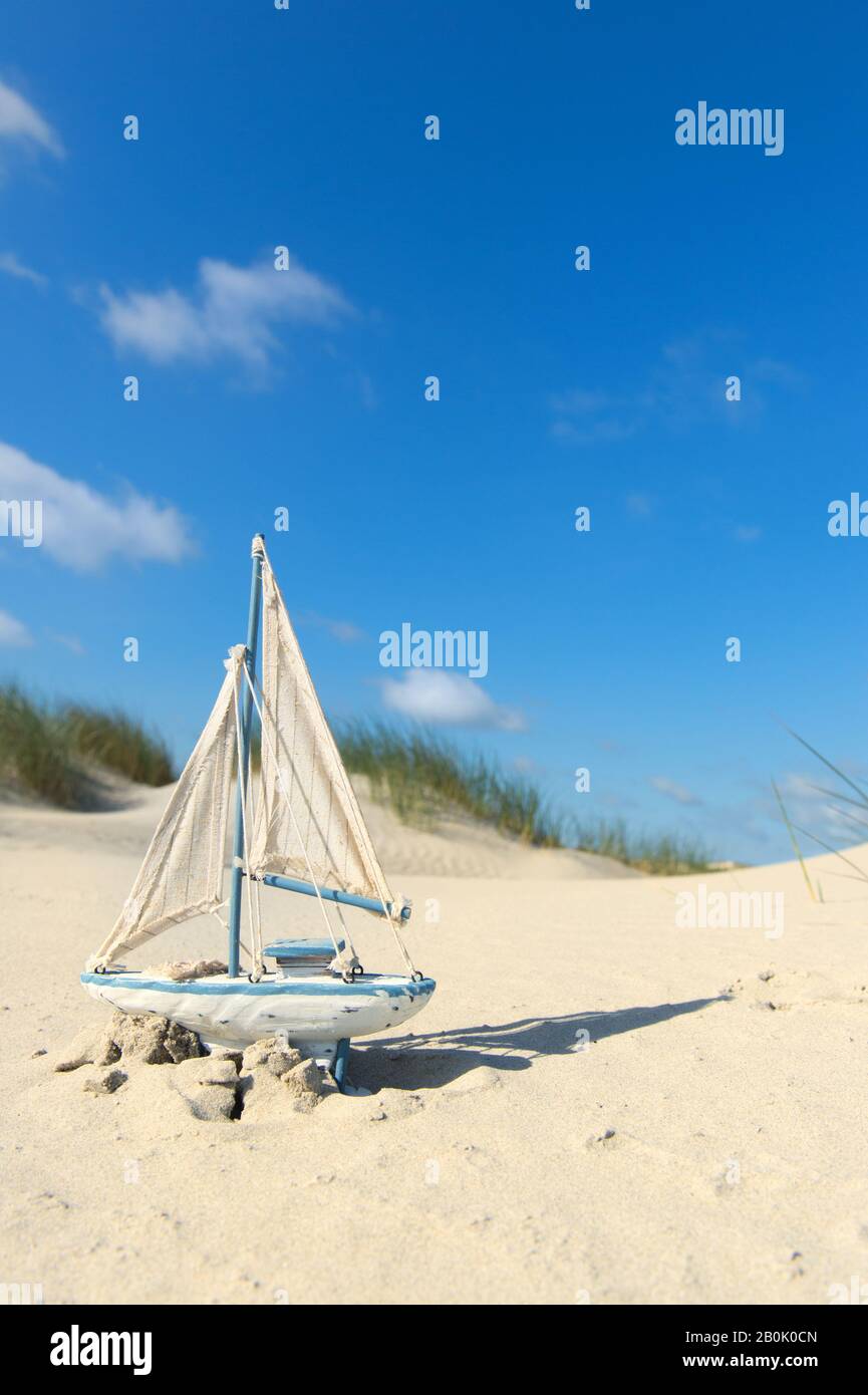 Barco de juguete en las dunas de la playa Foto de stock