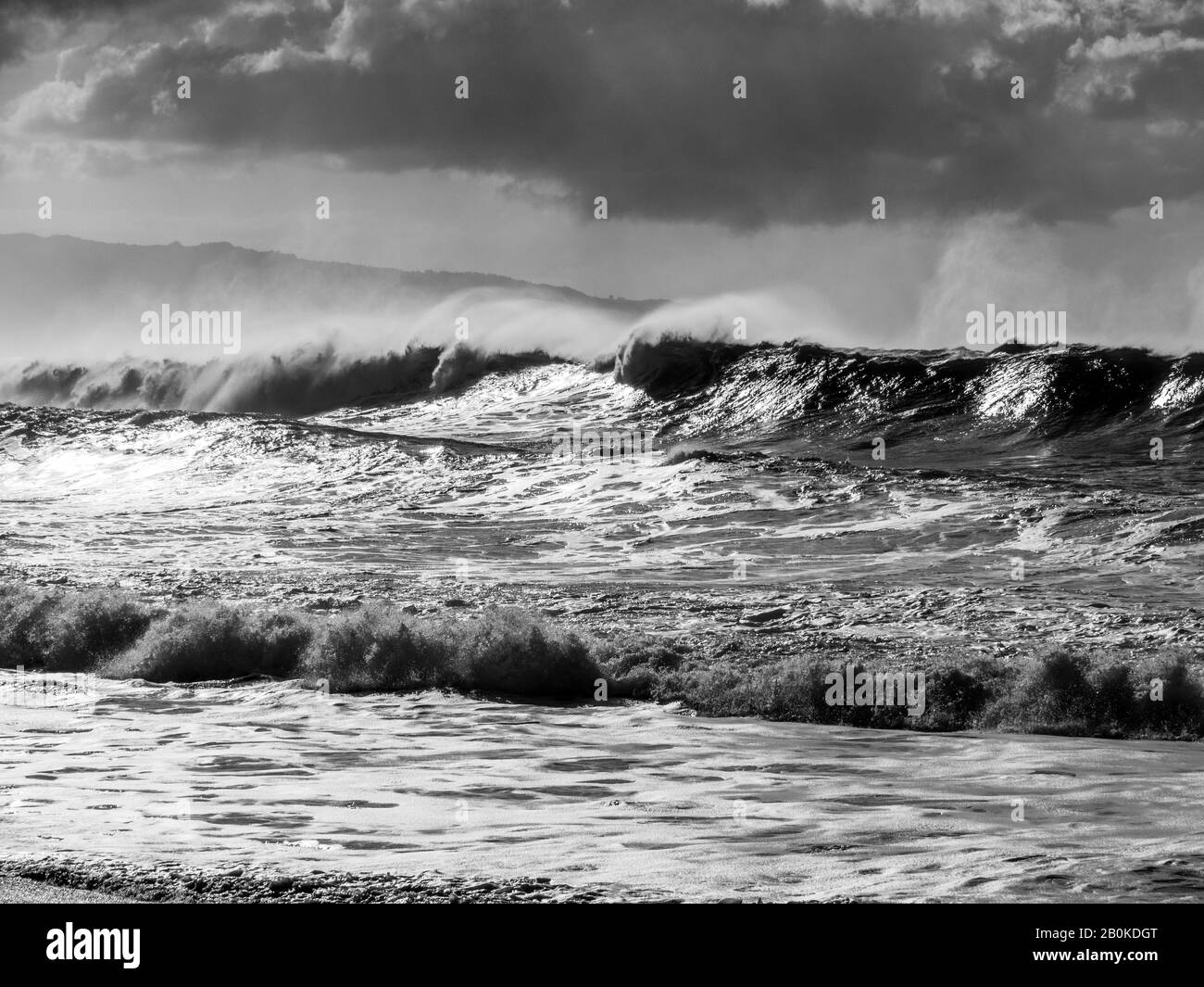 Blanco y negro de grandes olas en la costa norte de Oahu con cielos grises antes del inicio de la tormenta. Foto de stock