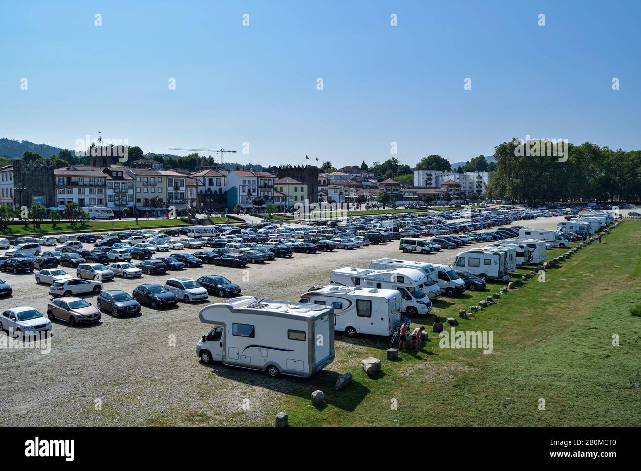 Aparcamiento completo en el campo da feira Ponte de lima cerca del río río Lima en Portugal. Efectos del turismo en los lugares rurales. Aparcamiento muy concurrido. Foto de stock