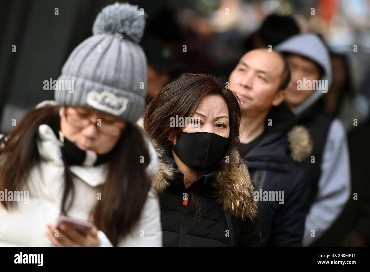 Nueva York, EE.UU. 20 de febrero de 2020. Una mujer usa una máscara protectora mientras camina en la sección de Flushing del distrito de Queens, NY, en la ciudad de Nueva York, el 20 de febrero de 2020. La Organización Mundial de la Salud ha declarado una emergencia mundial de salud pública a medida que los casos de las nuevas infecciones mortales por coronavirus COVID-19 ascienden a más de 75,000 en todo el mundo y las muertes reportadas superan los 2000. (Anthony Behar/Sipa Usa) Crédito: Sipa Usa/Alamy Live News Foto de stock