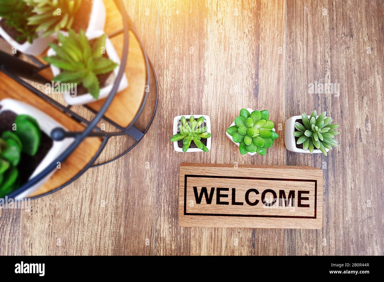 cálido signo de bienvenida para el concepto de negocio. madera signo de bienvenida en la mesa decorar con un pequeño cactus y espacio de copia para su texto, vista superior Foto de stock