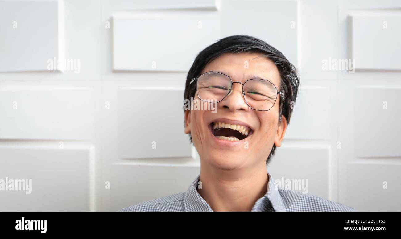 El hombre asiático mayor sonrió y rió feliz Foto de stock