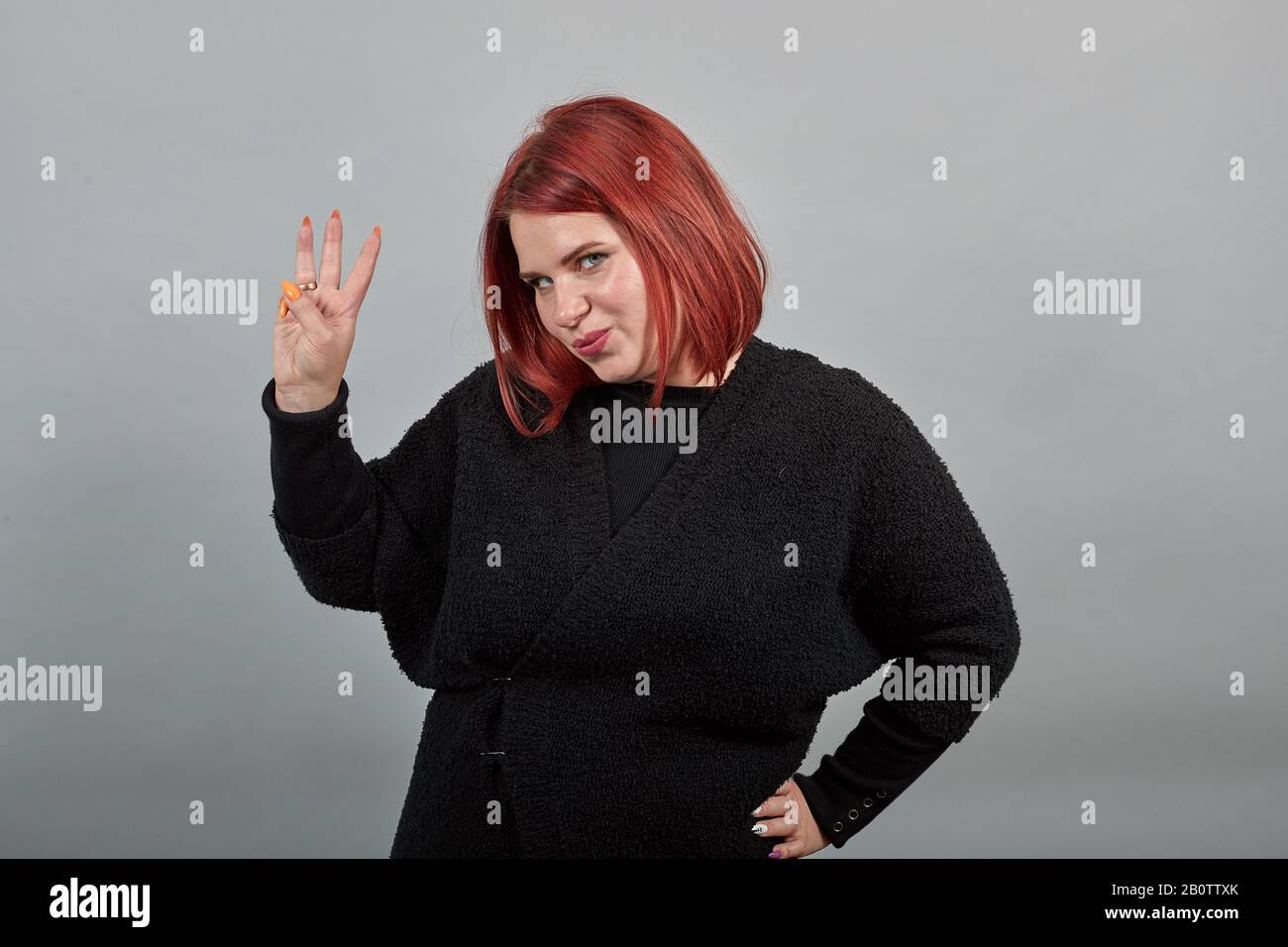 Joven mujer gorda de pelirroja en suéter negro elegante mujer muestra tres  sonrisas de los dedos Fotografía de stock - Alamy
