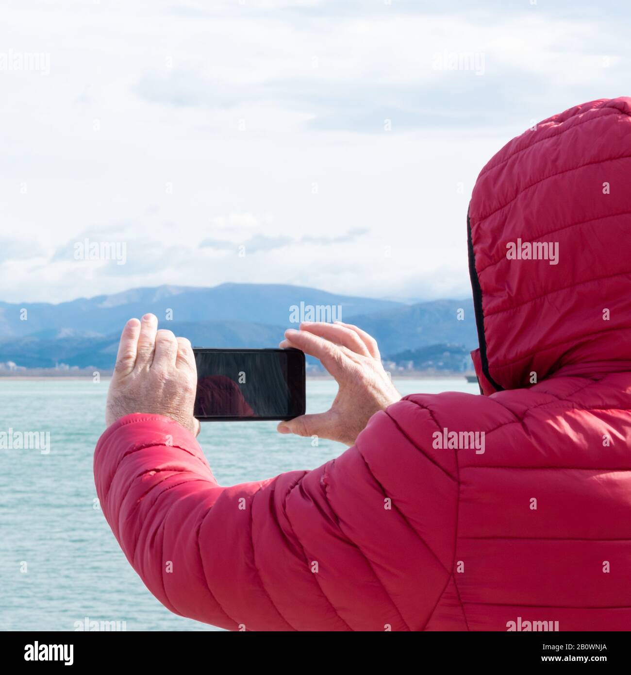 Hombre irreconocible que toma fotos con smartphone. Admirando la naturaleza, la lujuria Foto de stock