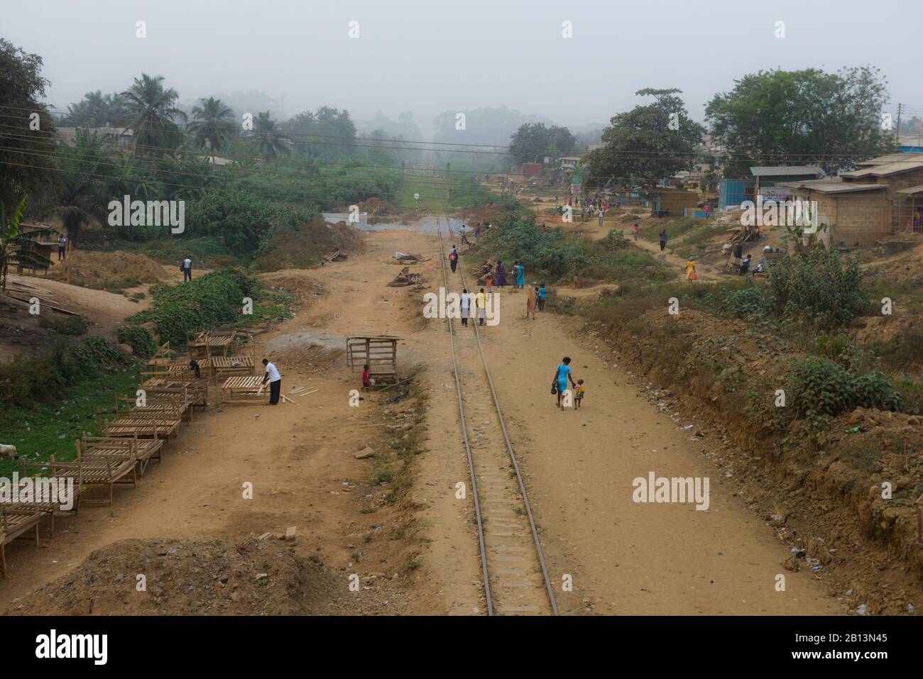 Las vías del ferrocarril, a través de un pueblo en el sur de Ghana Foto de stock