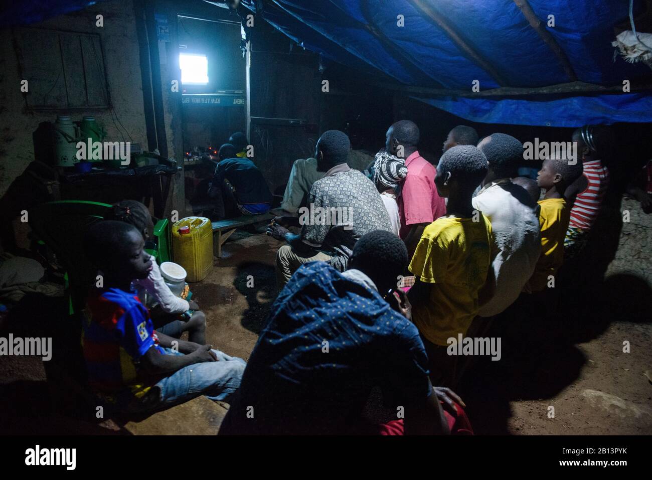 Noche de televisión en un remoto pueblo sin electricidad, Guinea Foto de stock