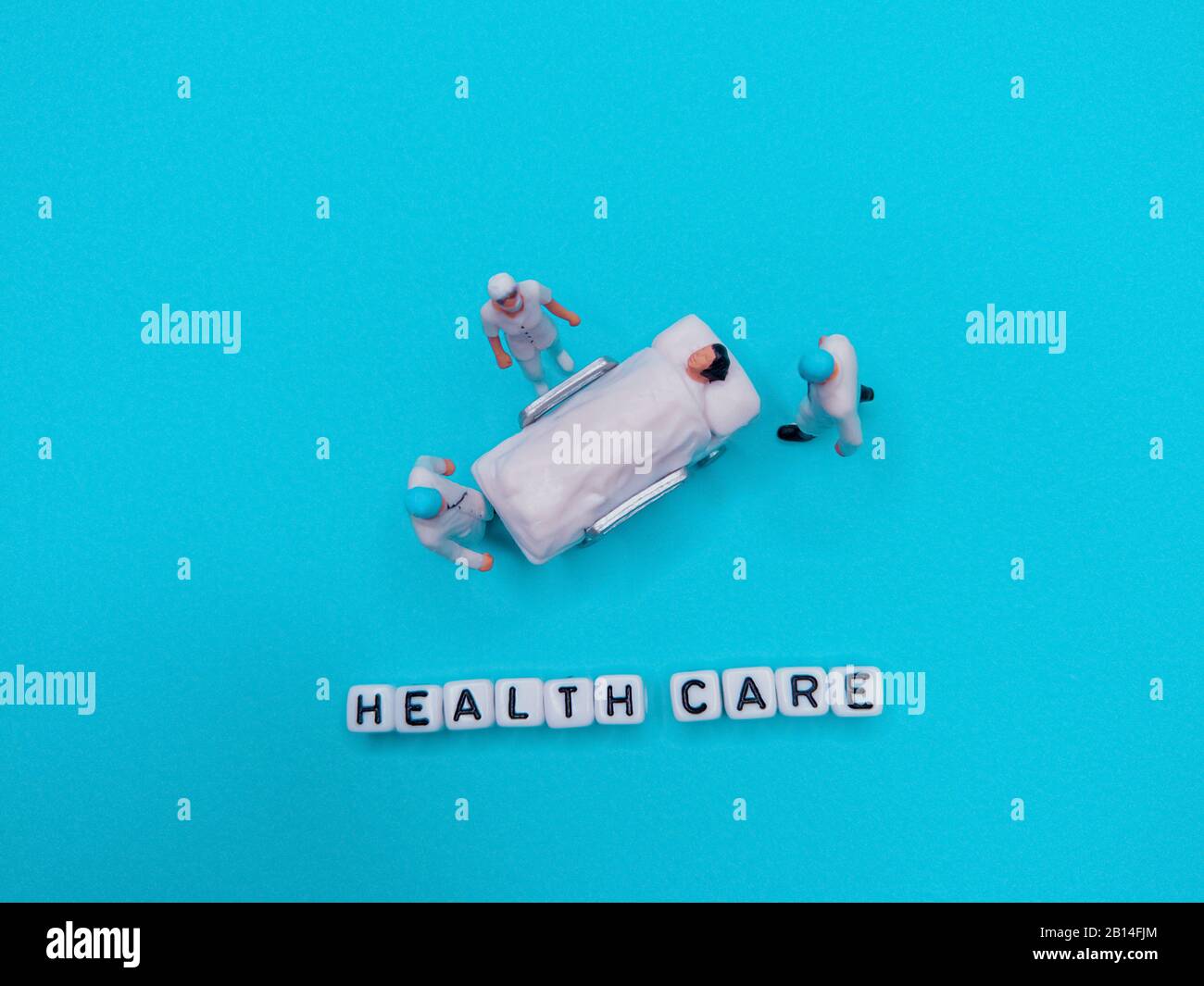 Miniatura juguete médico personas - sentencias de atención médica con fondo azul o verde azulado Foto de stock