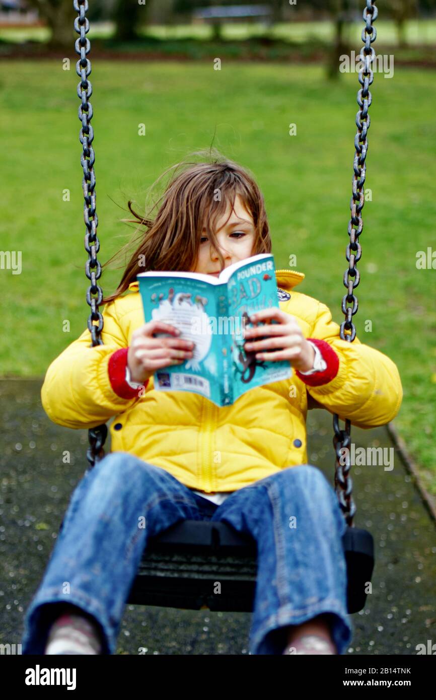 Chica leyendo en un parque Foto de stock