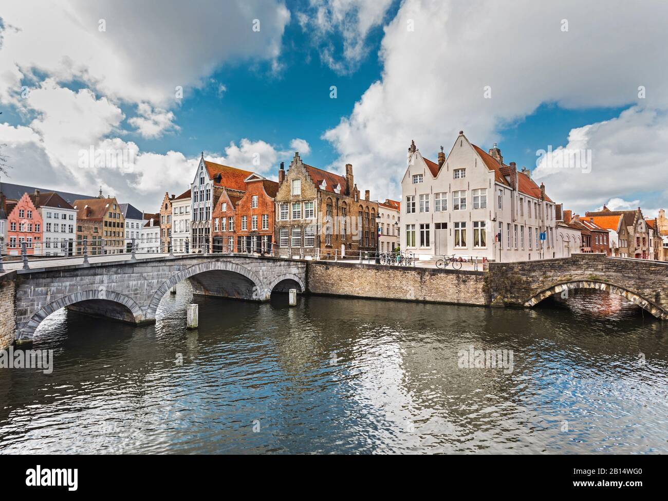 Viejas casas de piedra coloridas cerca del canal son el punto de referencia de Brujas, Bélgica. Los canales de Brujas con viejos puentes de piedra son una atracción turística famosa. Foto de stock