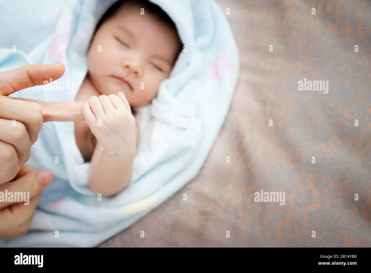 Concepto de amor y relación familiar : primer plano recién nacido asiático mano de bebé sostener la mano alrededor de la madre dedo con espacio de copia en el lado derecho. Asia bebé Foto de stock