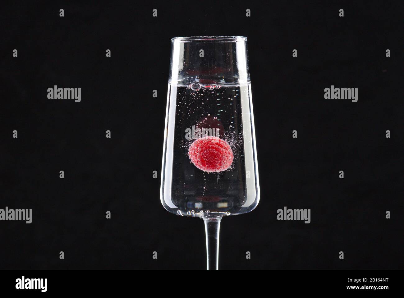Una frambuesa flotando en champán Foto de stock
