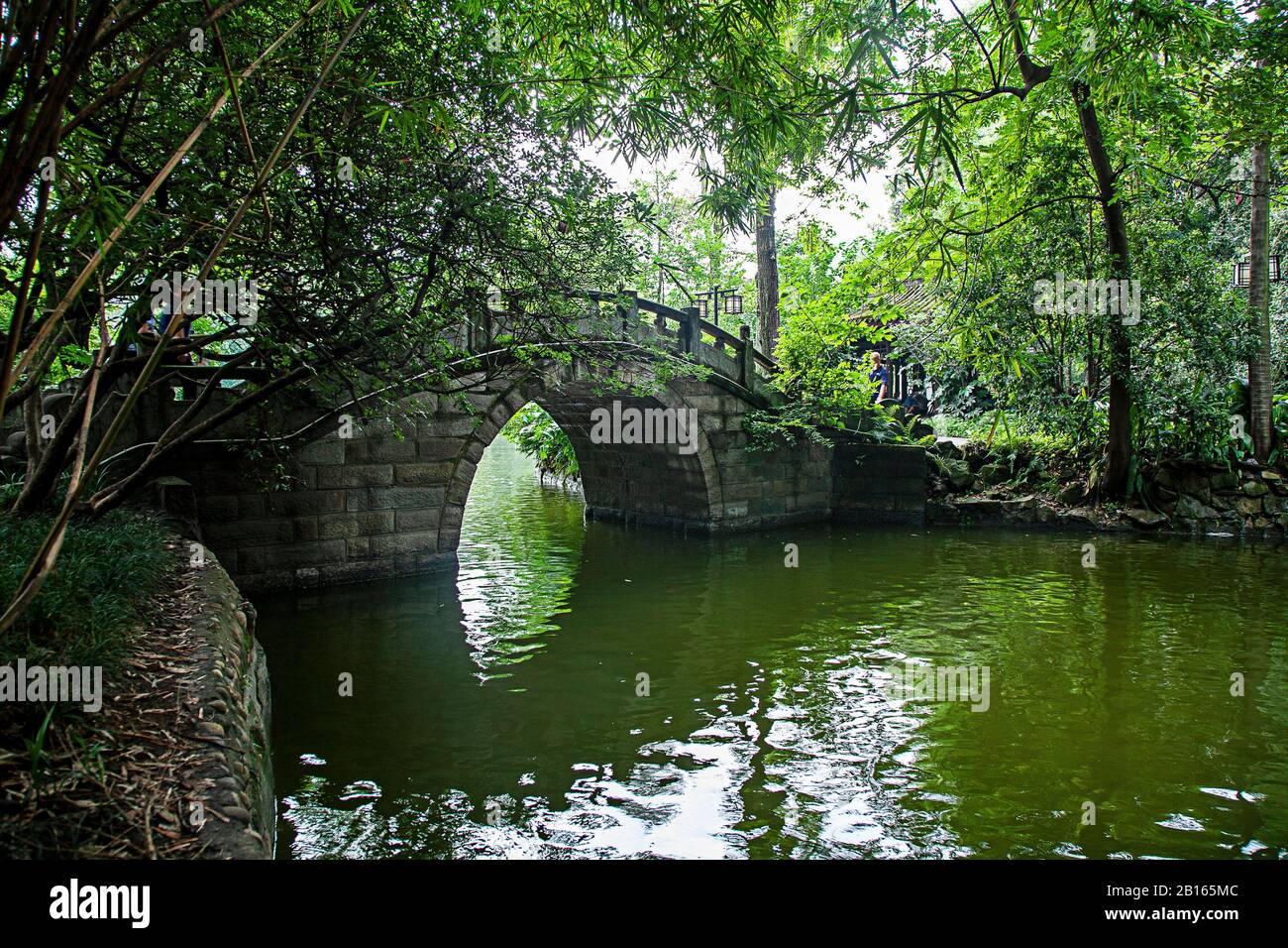 Puente de piedra sobre una pequeña corriente en Chengdu People's Park China Foto de stock