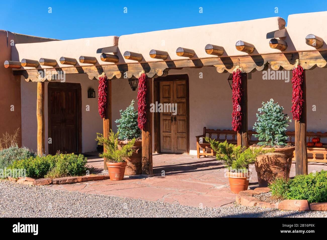 Casa de estilo pueblo con arquitectura de adobe con ristras (chiles rojos secos) en Santa Fe, Nuevo México, Estados Unidos Foto de stock