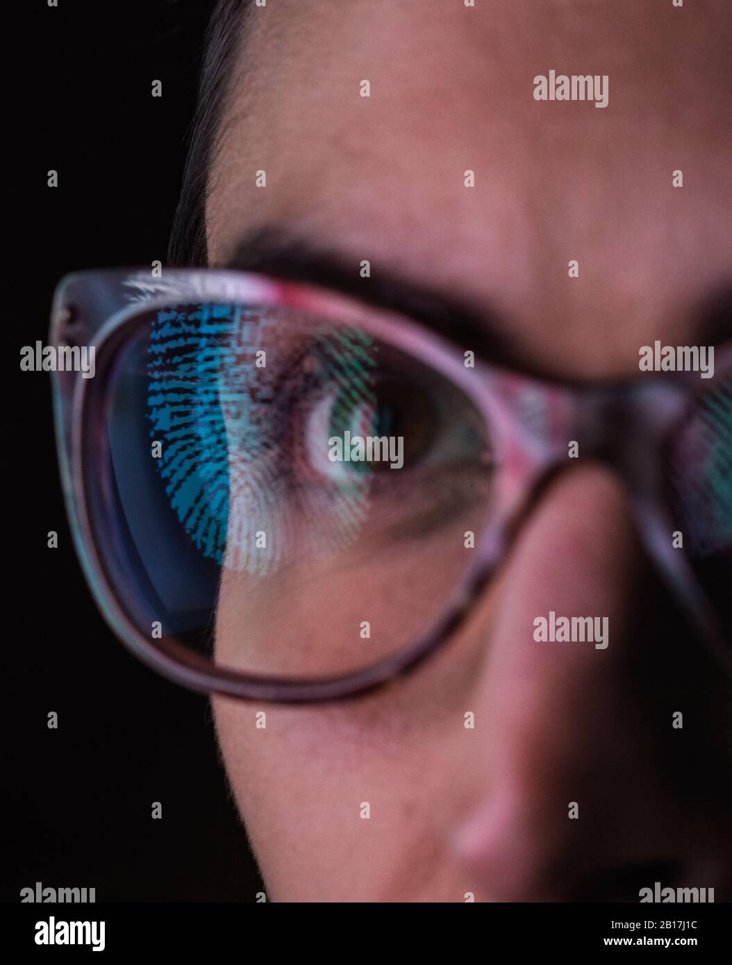 Mujer con un reflejo de una huella en sus gafas para representar identidad y acceso Foto de stock