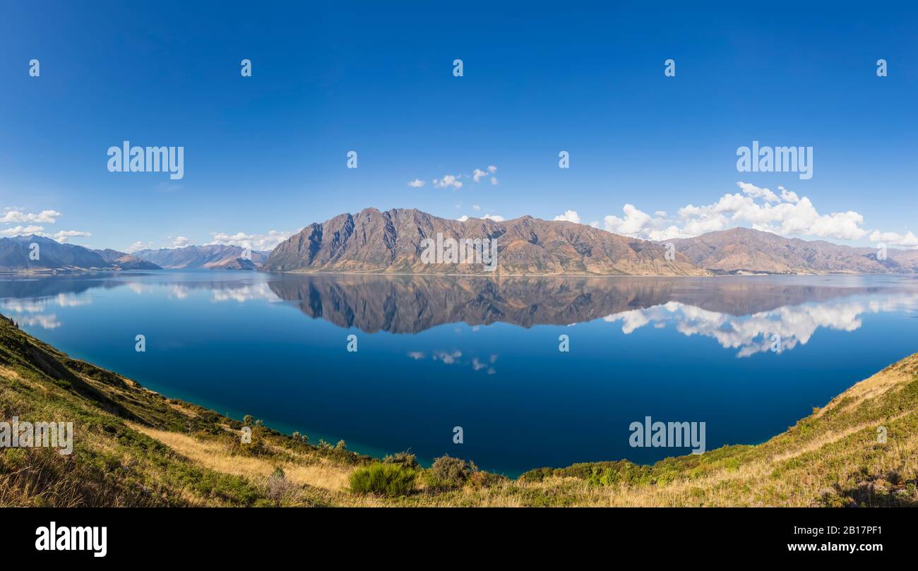 Nueva Zelanda, Queenstown-Lakes District, Wanaka, Vista panorámica de las colinas que se reflejan en el lago Hawea Foto de stock