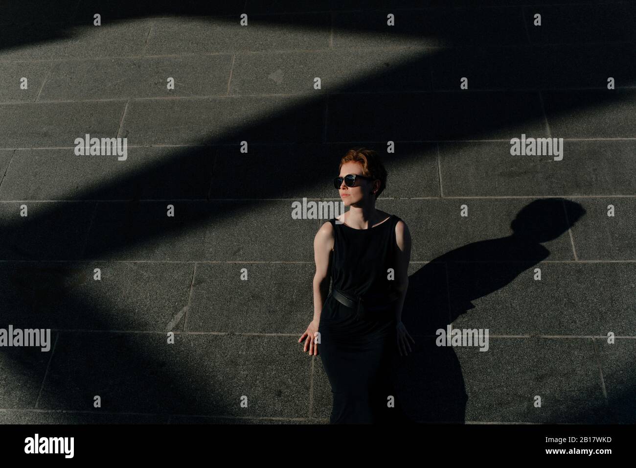 Foto de Mujer morena española de perfil en la oscuridad observa do Stock