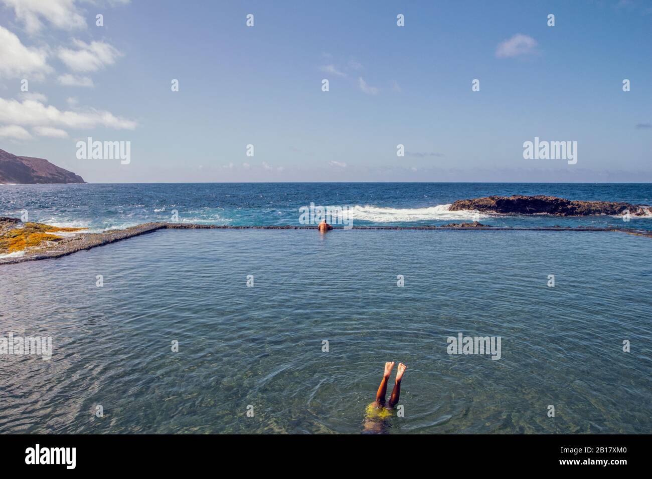 España, la Gomera, Hermigua, Hombre nadando en piscina de agua de mar Foto de stock