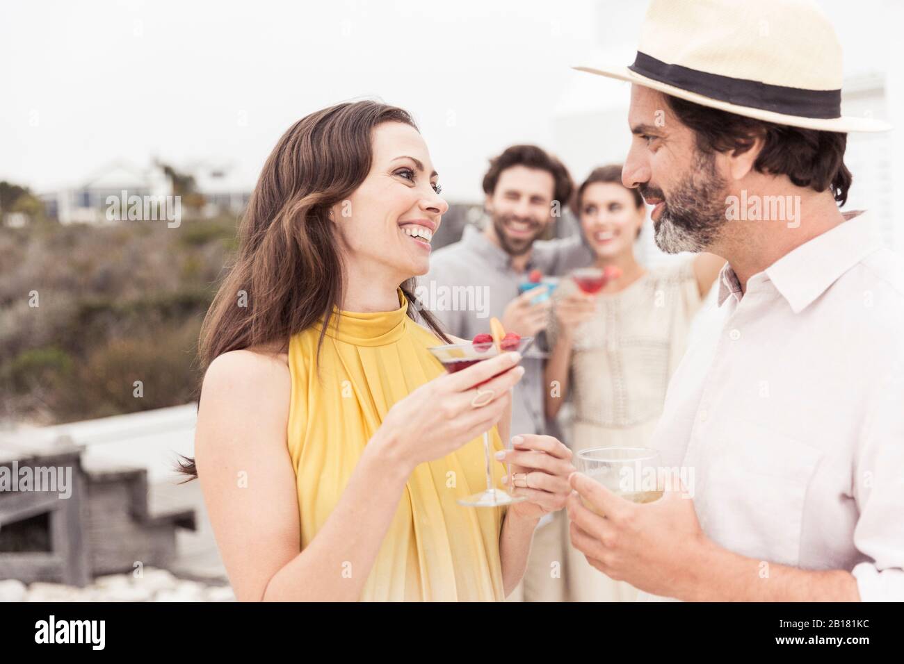 Pareja y amigos socializando en una fiesta de cóctel Foto de stock