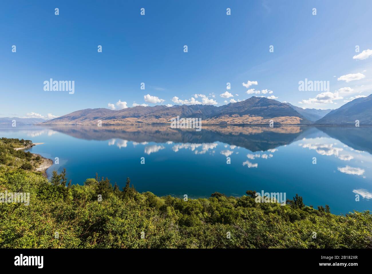 Nueva Zelanda, Queenstown-Lakes District, Wanaka, el cielo azul del verano que se refleja en el lago Wanaka Foto de stock