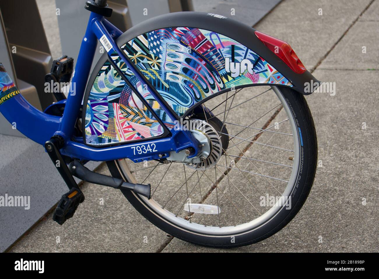 Bicicleta pública de Lyft aparcada en la estación de bikeshare con una colorida protección trasera de la capa de la rueda. Opción de transporte sostenible sin carbono. Berkeley, CA Foto de stock