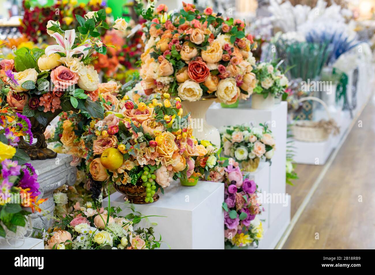 Ramo de rosas blancas y amarillas artificiales con hojas y frutas, diseño  interior una fila de ramos en una tienda de flores, decoración tejido  floral artificial Fotografía de stock - Alamy