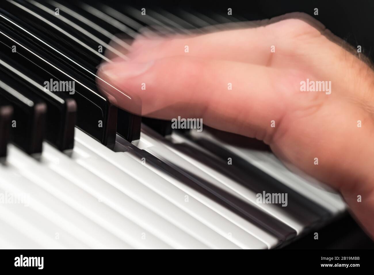 Mano moviéndose rápidamente sobre notas o teclas de un piano o teclado  sintetizador reproduciendo música rápidamente, mostrando desenfoque de  movimiento. Concepto de músico Fotografía de stock - Alamy