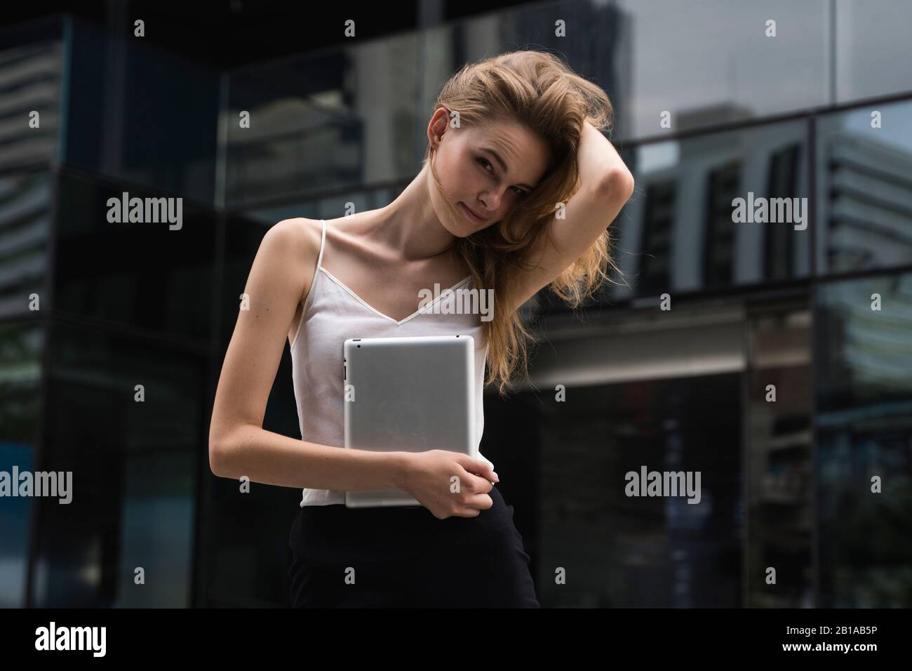 Retrato de mujer de negocios sosteniendo un equipo tablet PC. Mujer de negocios en una reunión y esperando business partner y sosteniendo una tableta en manos Foto de stock