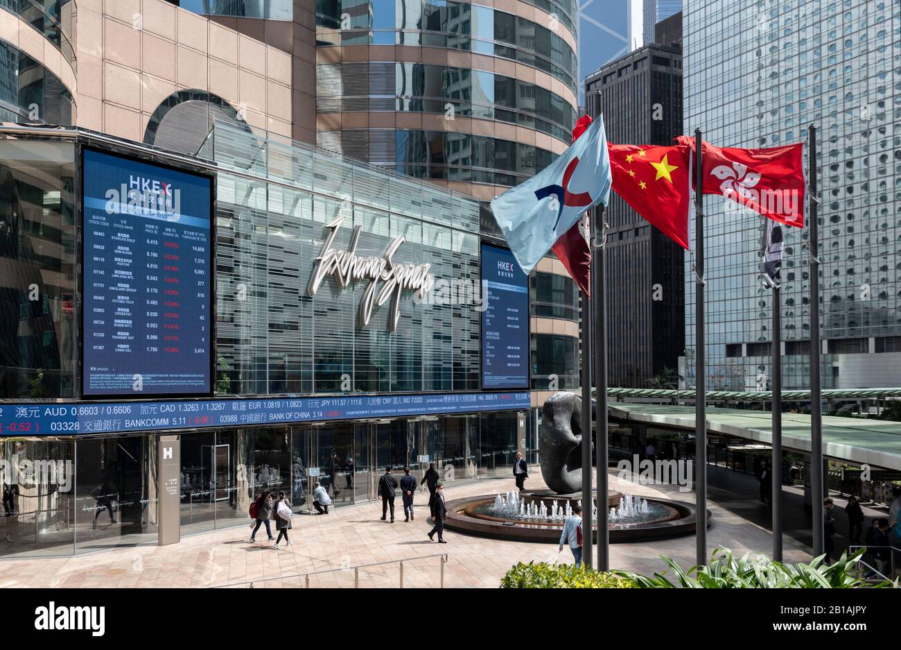Banderas de Hong Kong (R), China (M) y la Bolsa de valores de Hong Kong  Limited (L) frente a la junta del índice Heng Sang de la plaza del mercado,  Central.los mercados