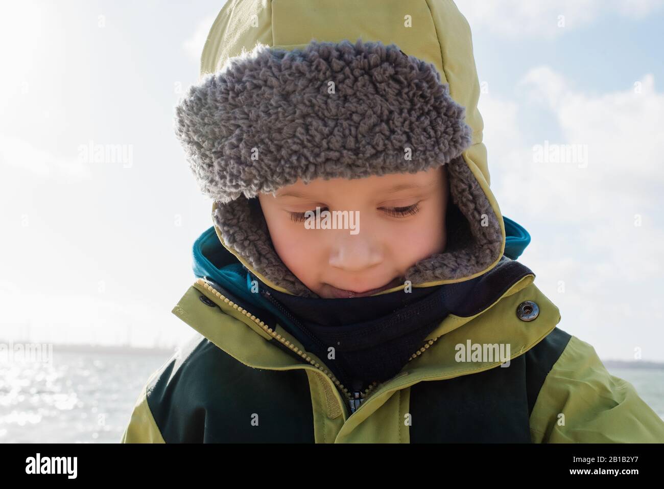retrato de un niño envuelto en calor en la playa en invierno Foto de stock