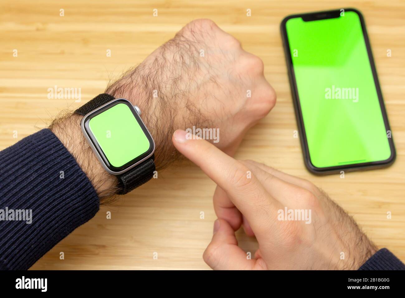 Imagen de la pantalla verde táctil del reloj inteligente en la muñeca.  Teléfono móvil negro con pantalla verde en la mesa de la oficina sobre el  fondo Fotografía de stock - Alamy