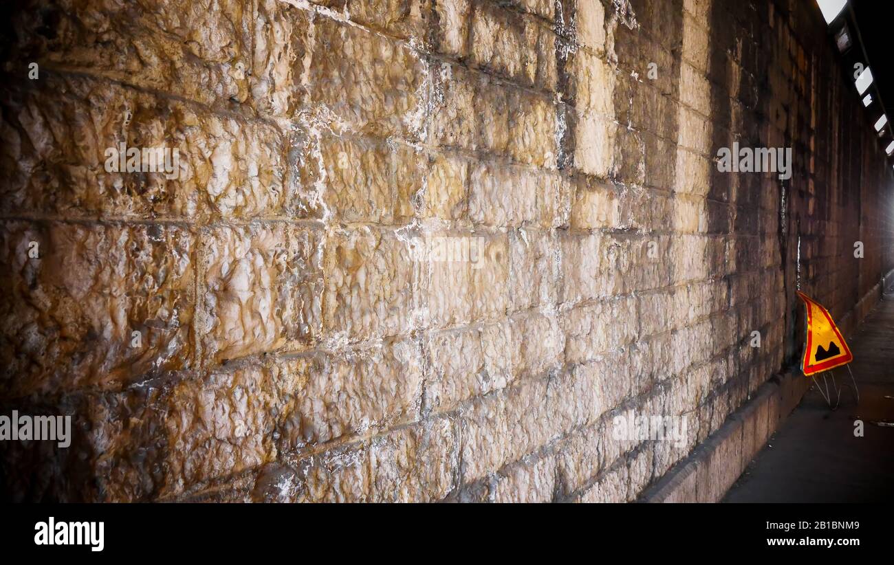 Pared de piedra con una placa de carretera amarilla, Lyon, Francia Foto de stock