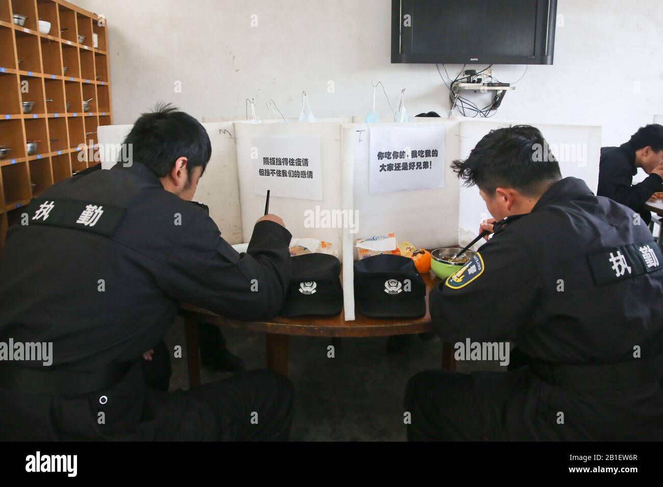 Los policías chinos y los policías auxiliares comen el almuerzo solos y por separado para la prevención epidémica del nuevo coronavirus y pneumonis en un bloque Foto de stock
