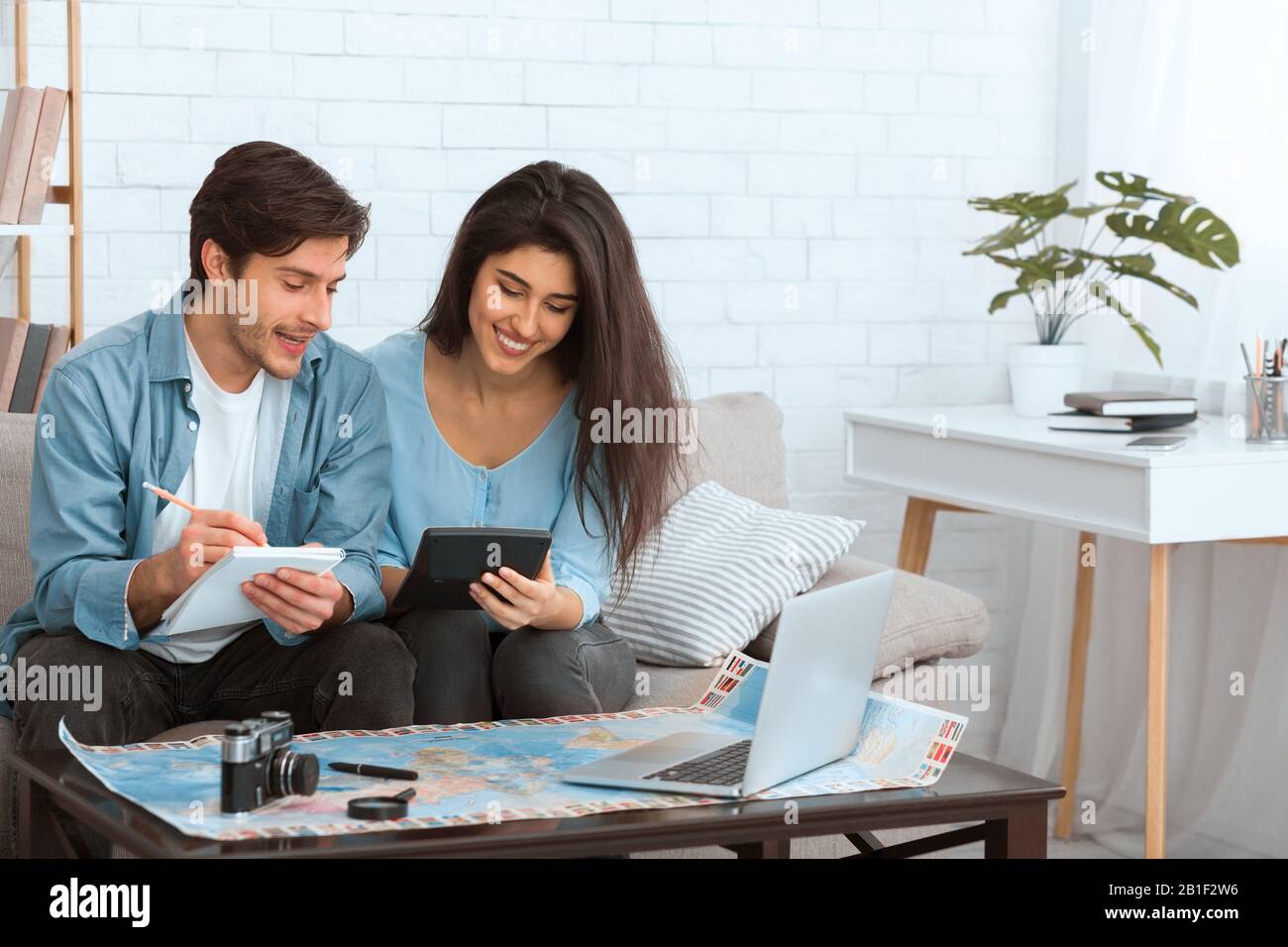 Planear las finanzas. Pareja preparándose para vacaciones y calculando gastos Foto de stock