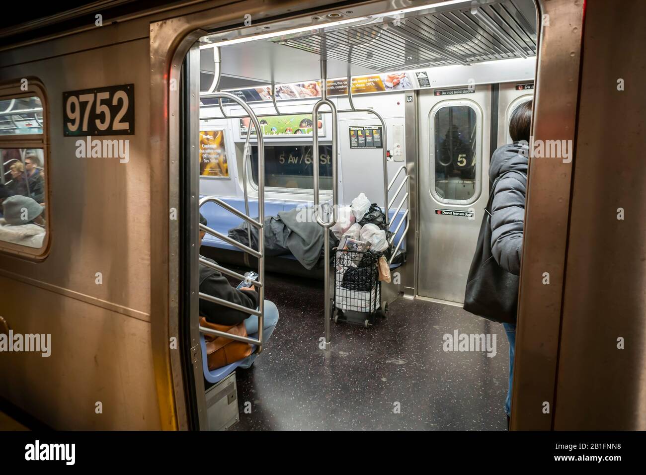 Un hombre sin hogar duerme en un tren subterráneo en Nueva York el sábado, 22 de febrero de 2020. (© Richard B. Levine) Foto de stock