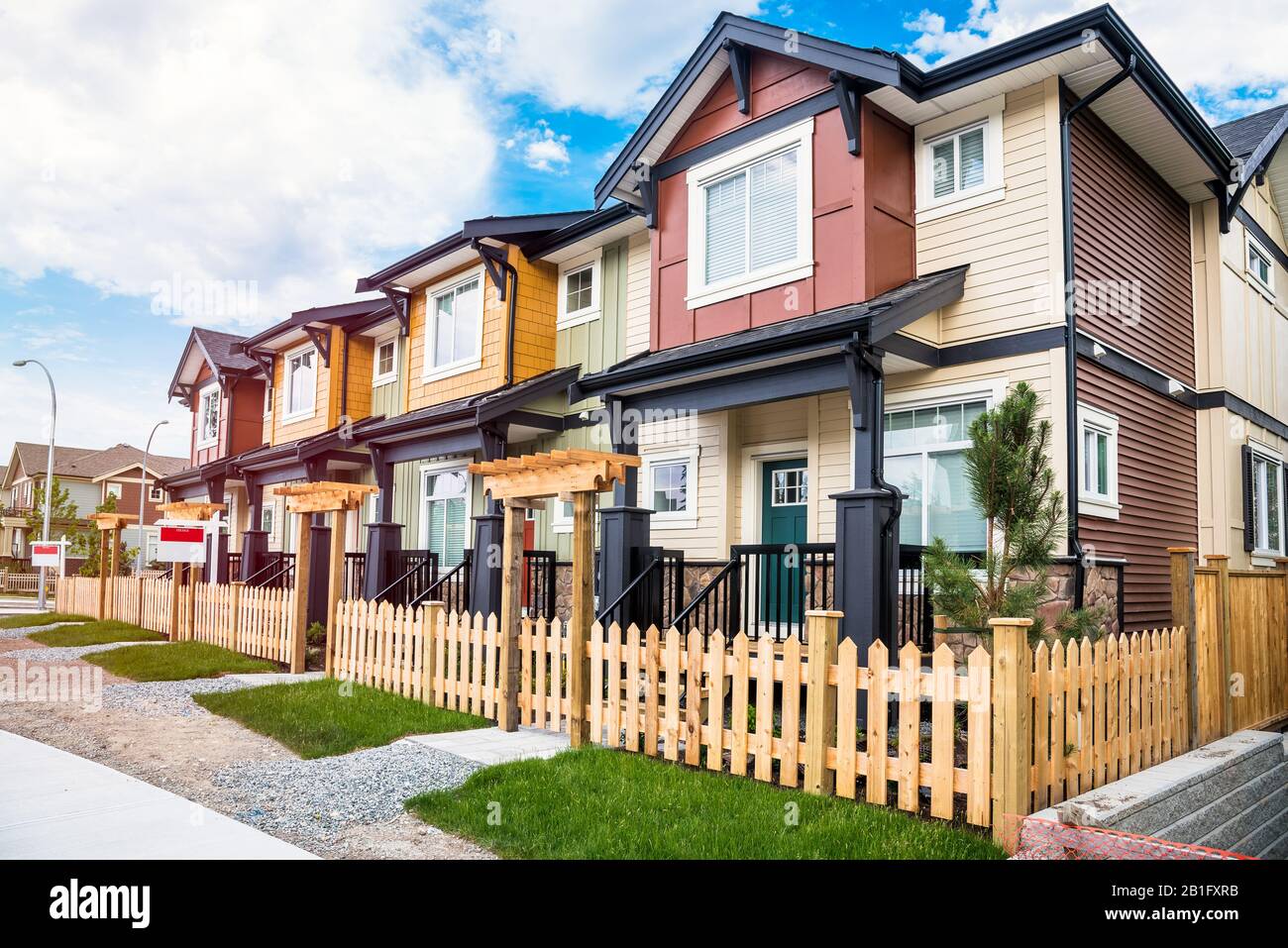 Nuevas casas en hilera con jardines frente vallados a la venta en un desarrollo de viviendas. Langley, BC, Canadá. Foto de stock