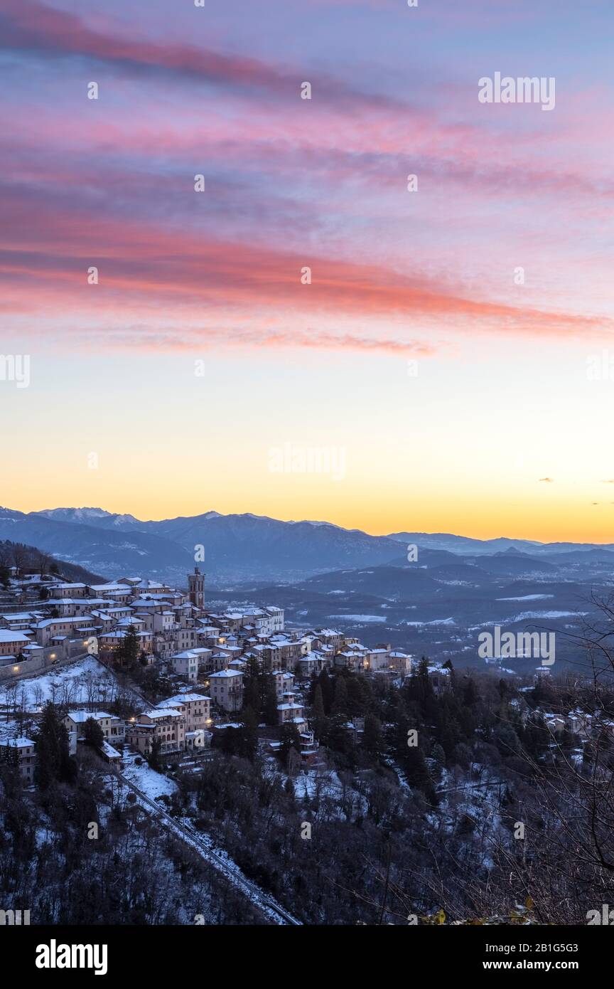 Vista por la mañana de la ciudad de Santa Maria del Monte después de una Nevada en invierno desde el campo dei Fiori. Foto de stock