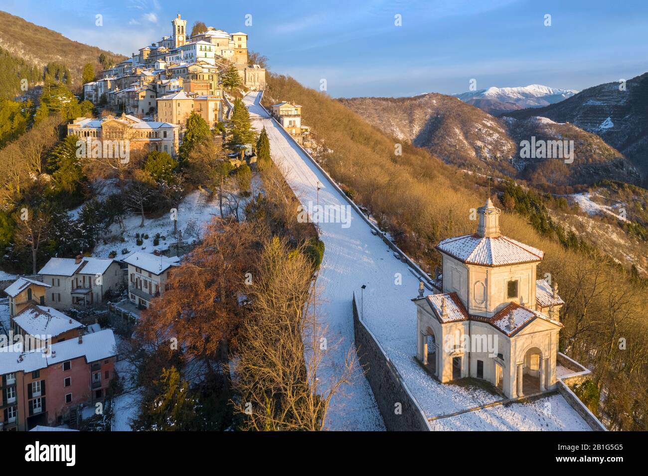 Vista aérea de Santa Maria del Monte y las capillas del camino sagrado durante un amanecer de invierno. Sacro Monte Di Varese, Varese, Lombardía, Italia. Foto de stock