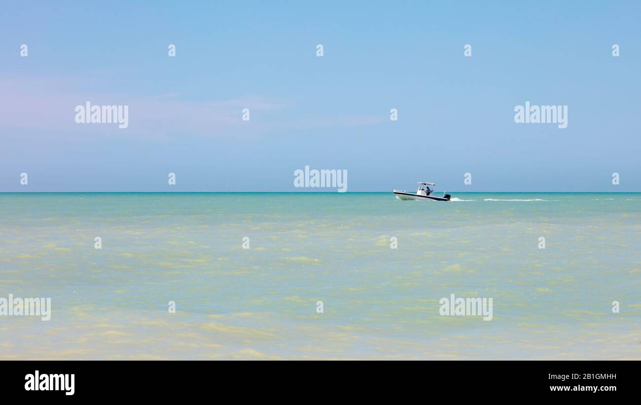 Océano tranquilo con barco, horizonte y cielo azul, Florida, Estados Unidos Foto de stock