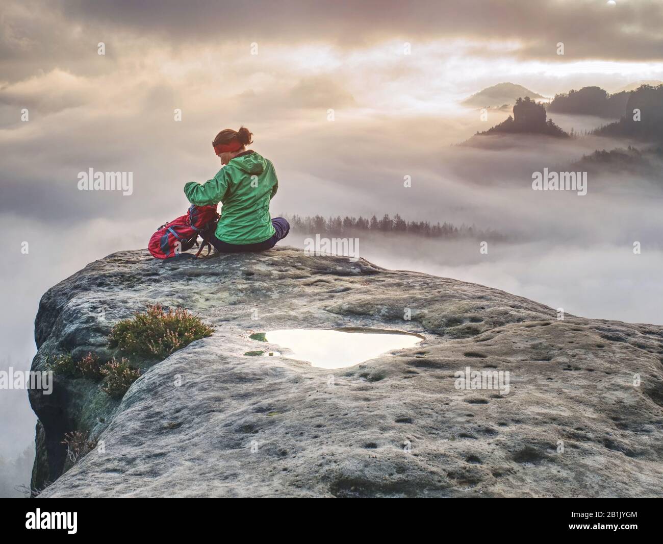 Las manos de las niñas en la cima de la montaña se levantaron sobre las nubes. Travel Lifestyle concepto de éxito aventura vacaciones activas al aire libre Foto de stock