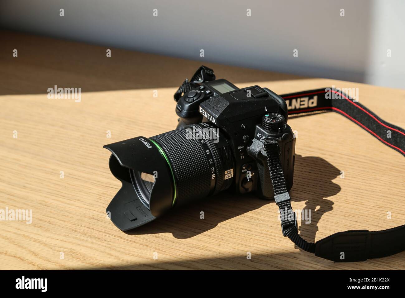 Cuerpo de la cámara DSLR Pentax K3 resistente al agua con kit lente de 18 mm sobre una mesa de madera bajo la luz del sol Fotografía de stock - Alamy